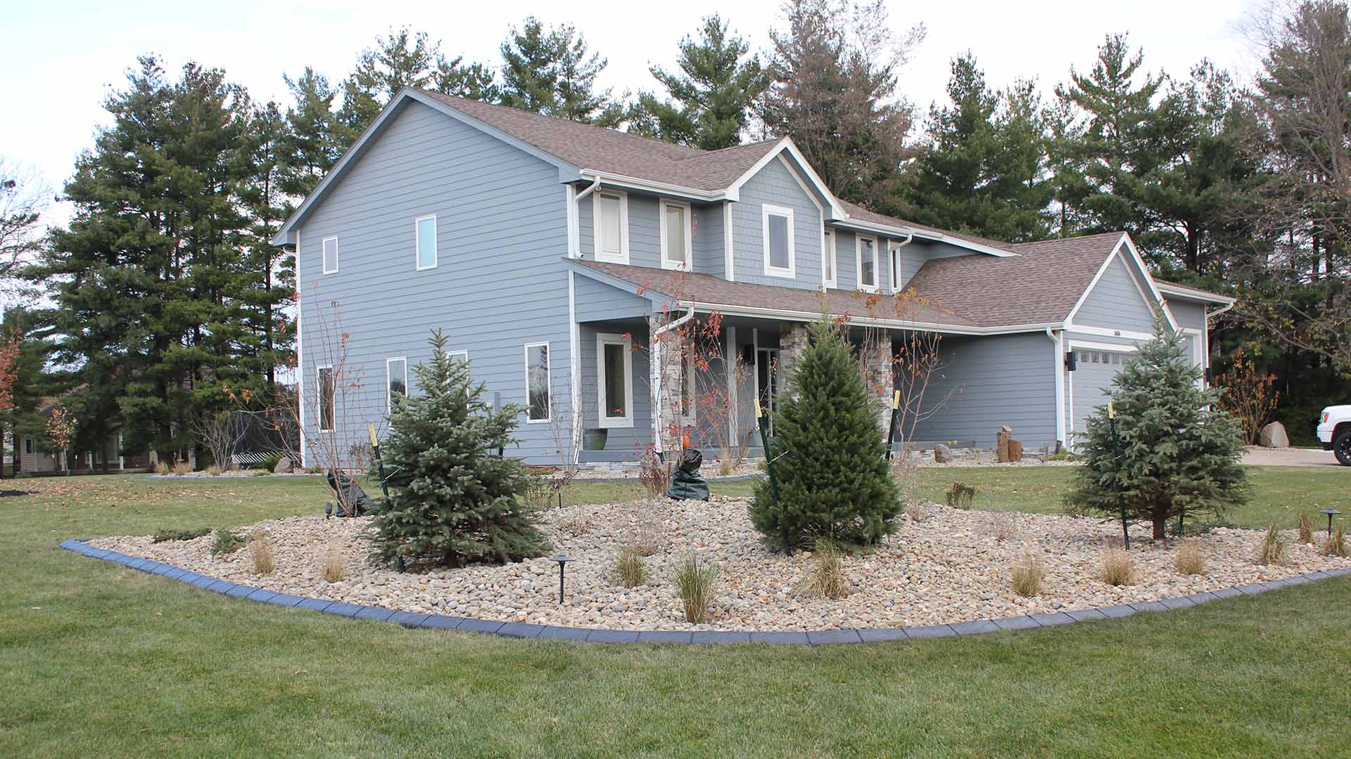Large home with a landscape bed with concrete edging added in Waukee, IA.