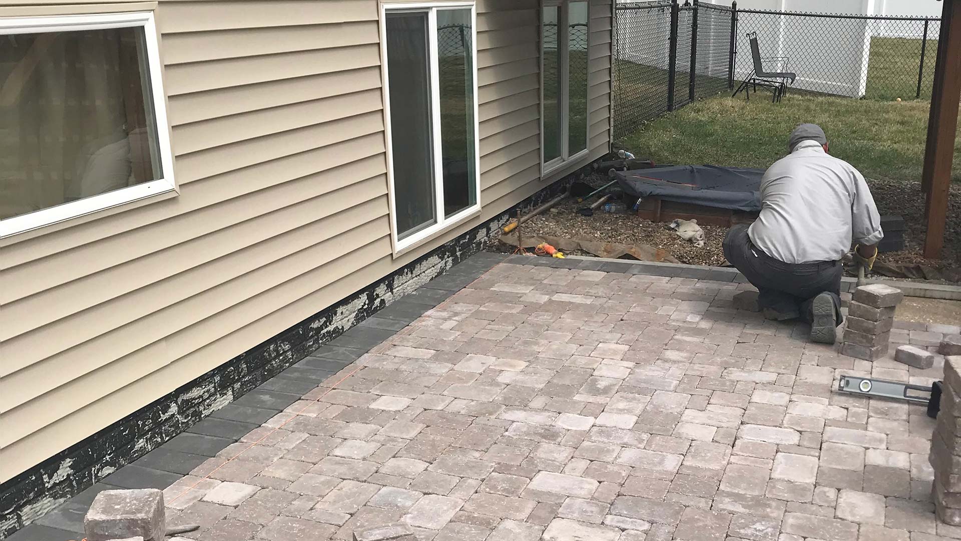 Professional installing a patio hardscape in Urbandale, IA.