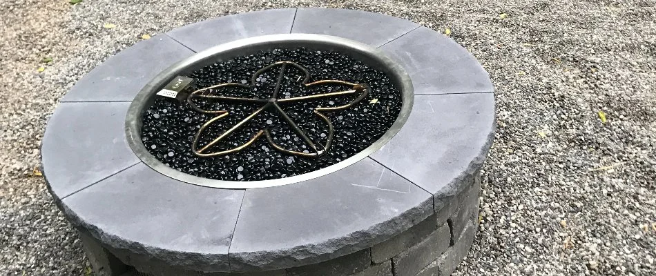 A fire pit in Waukee, IA, on grey gravel.