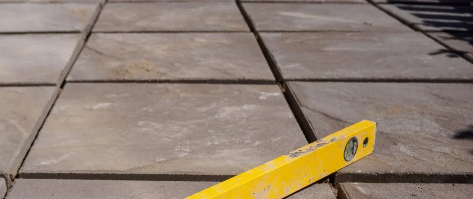 Levelling tool on a patio in Waukee, IA, with stack bond pattern.