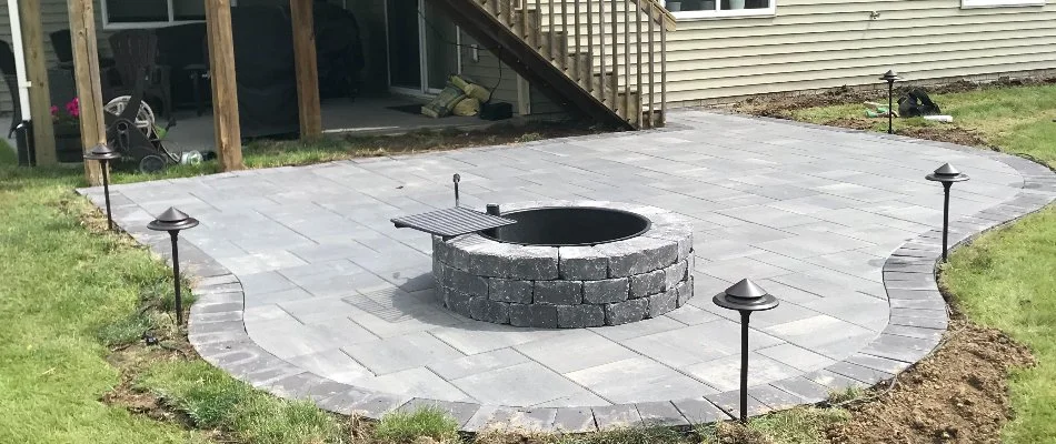 Patio in Waukee, IA, with fire pit and outdoor lighting.