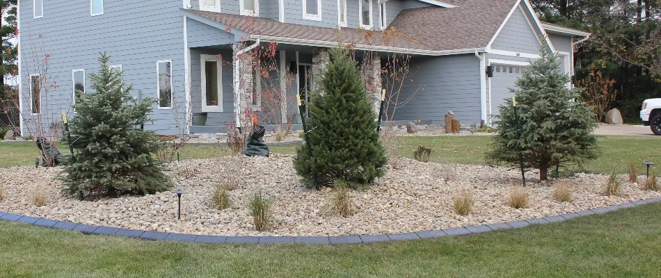 Rock landscaping in Waukee, IA, with three trees.