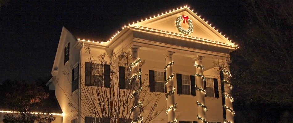 Warm white holiday lighting and wreath on a house in Waukee, IA.