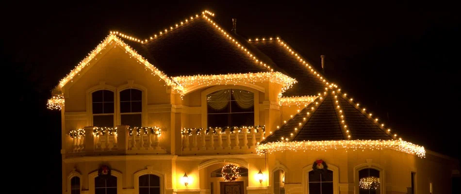 Roof of a house in Waukee, IA, with warm white holiday lights.
