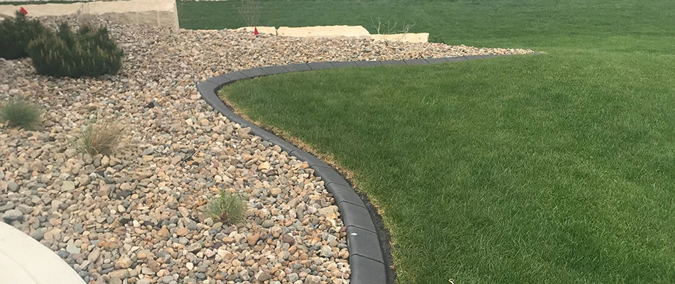 Edging installed by landscape bed and healthy lawn in Waukee, IA.