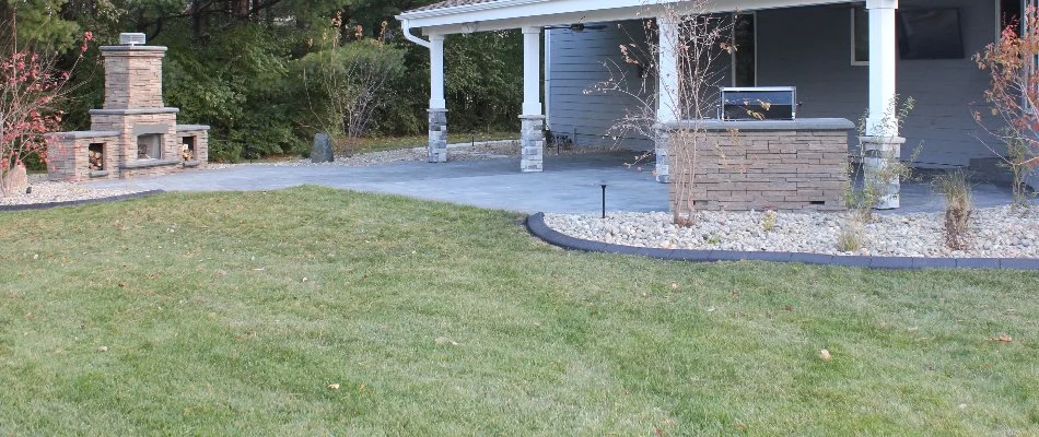 Green lawn in Booneville, IA, in front of a patio and an outdoor fireplace.