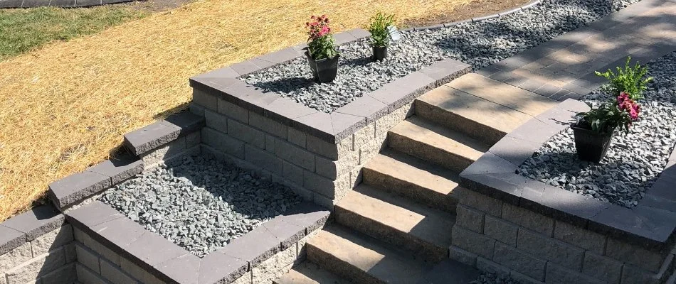 Landscape bed in Dallas Center, IA, with rocks and plants along outdoor steps.