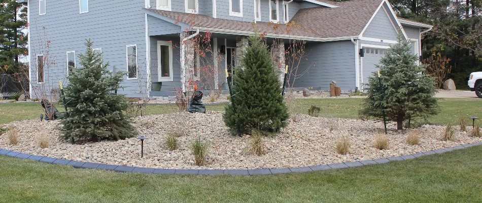 Landscape bed with rocks and trees in Andrew, IA.