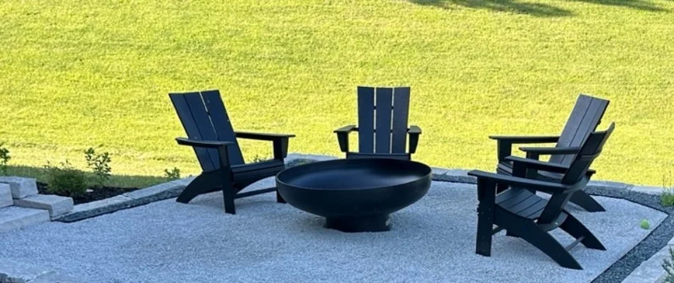 Lawn behind a patio with fire pit and chairs in Booneville, IA.