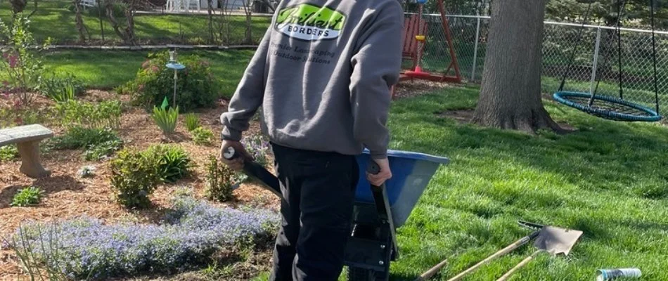 Person gardening with equipment in residential yard, Urbandale, IA.