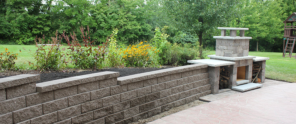 A retaining wall installed beside outdoor fireplace in Ankeny, IA.