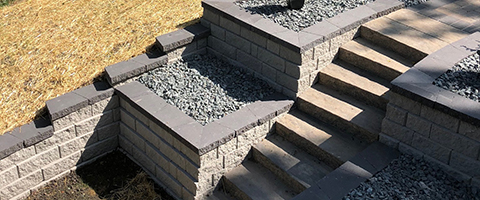 Retaining wall installed beside outdoor steps in Urbandale, IA.
