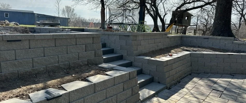 Tiered retaining walls and stone steps in a landscaped area, Waukee, IA.